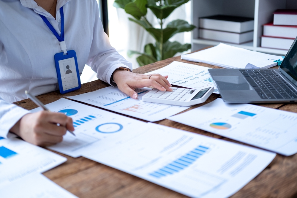 Accountant,Using,Calculator,And,Writing,On,Paper,,Business,Woman,Working