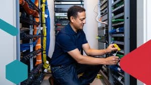 Expert IT technician managing and organizing network cables and servers in a data center for optimal performance.
