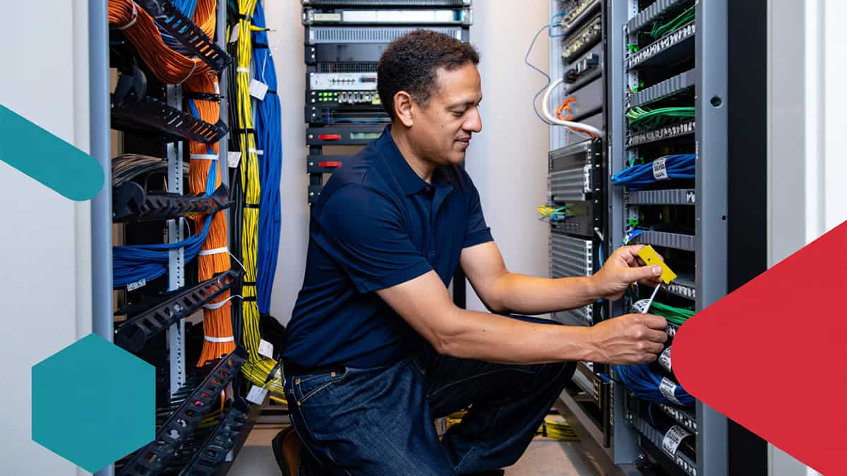 Expert IT technician managing and organizing network cables and servers in a data center for optimal performance.