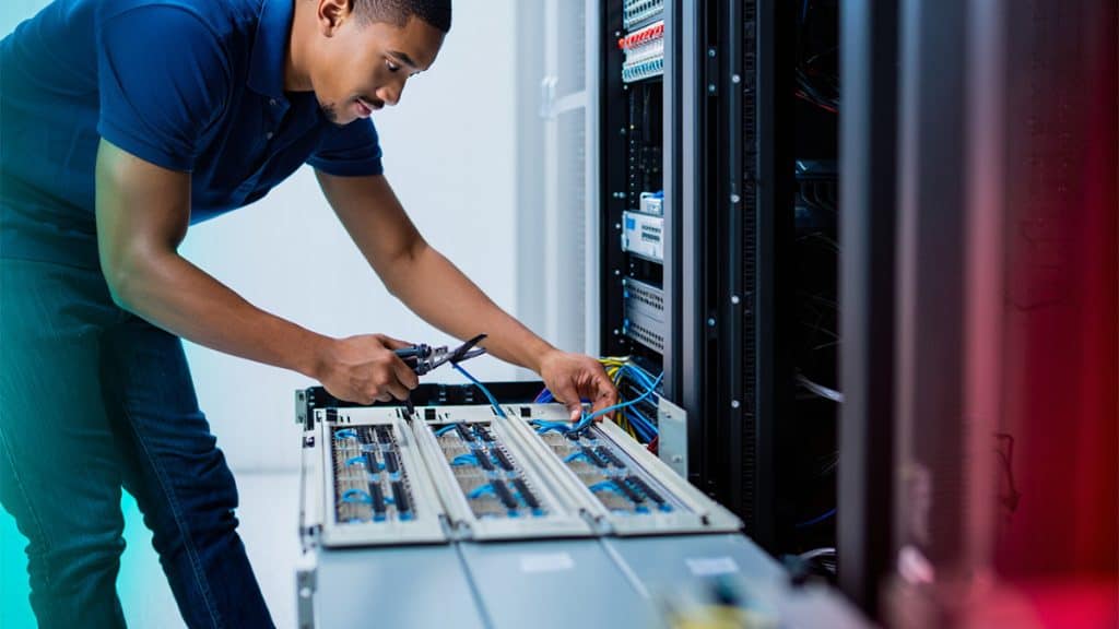 High-tech IT technician working on network cables in a server room at CNiC Solutions.