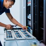 High-tech IT technician working on network cables in a server room at CNiC Solutions.
