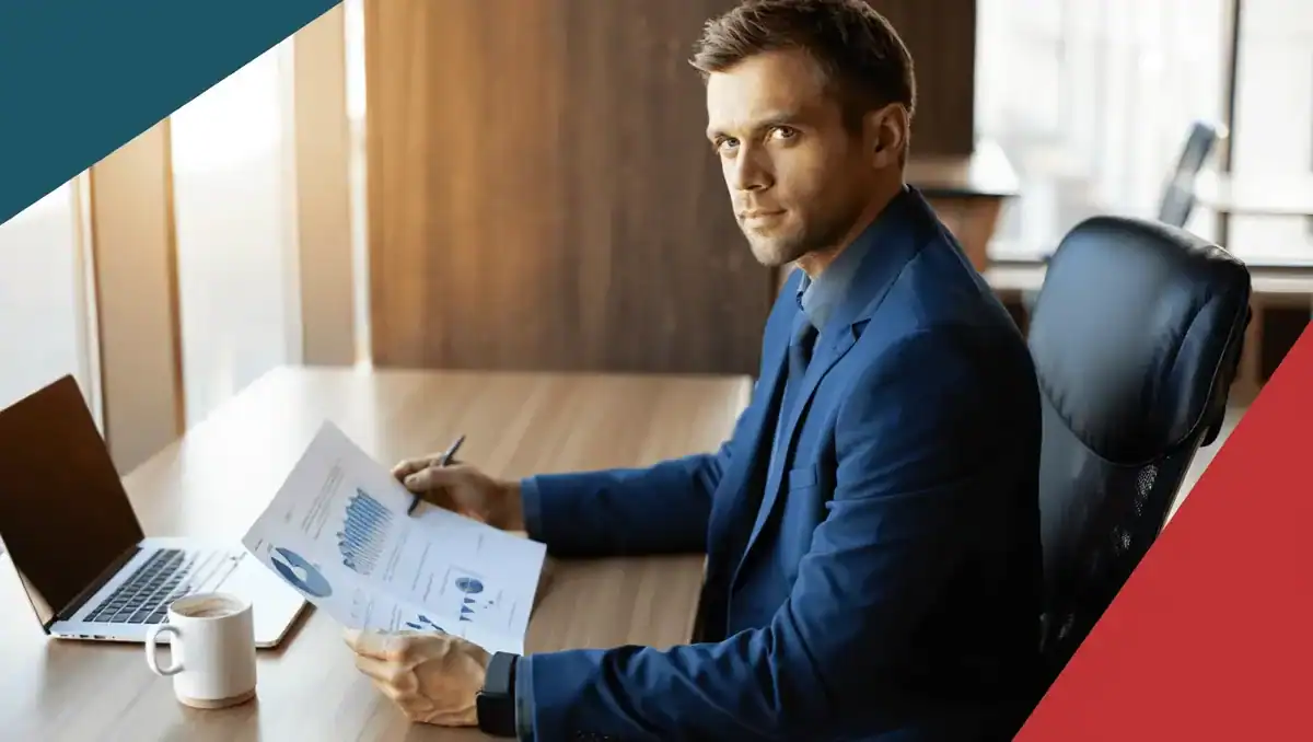 Business professional analyzing data and reports at a modern office desk.