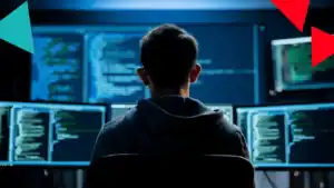 Person coding at a multi-monitor setup, back view, blue-toned code on screens in a dim lab.