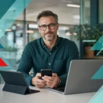 Business professional using mobile device with IT equipment in modern office setting.