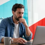 Business professional pausing before clicking a suspicious email on a laptop