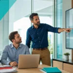 Small business team collaborating around a laptop and monitor on a shared digital workspace