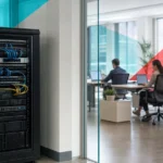 Small business server rack beside a modern open-plan office representing cloud versus on-premise infrastructure