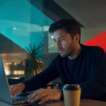 Distracted office worker at a laptop late in the day, illustrating human error in cybersecurity