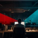 Employee working alone at a lit workstation in a dark office, illustrating after-hours insider access to company systems