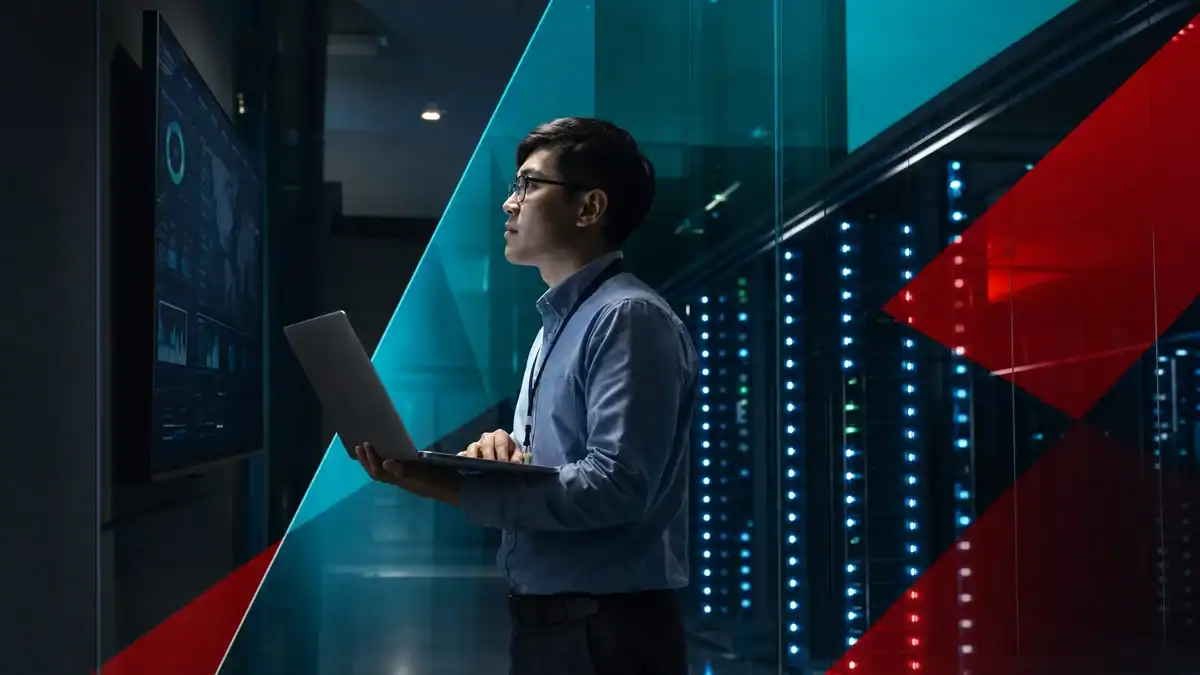 IT professional analyzing network data on a large digital screen in a data center.
