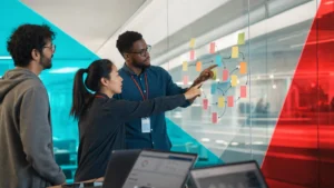 IT operations team working through a root cause analysis on a glass wall of notes to solve a recurring problem